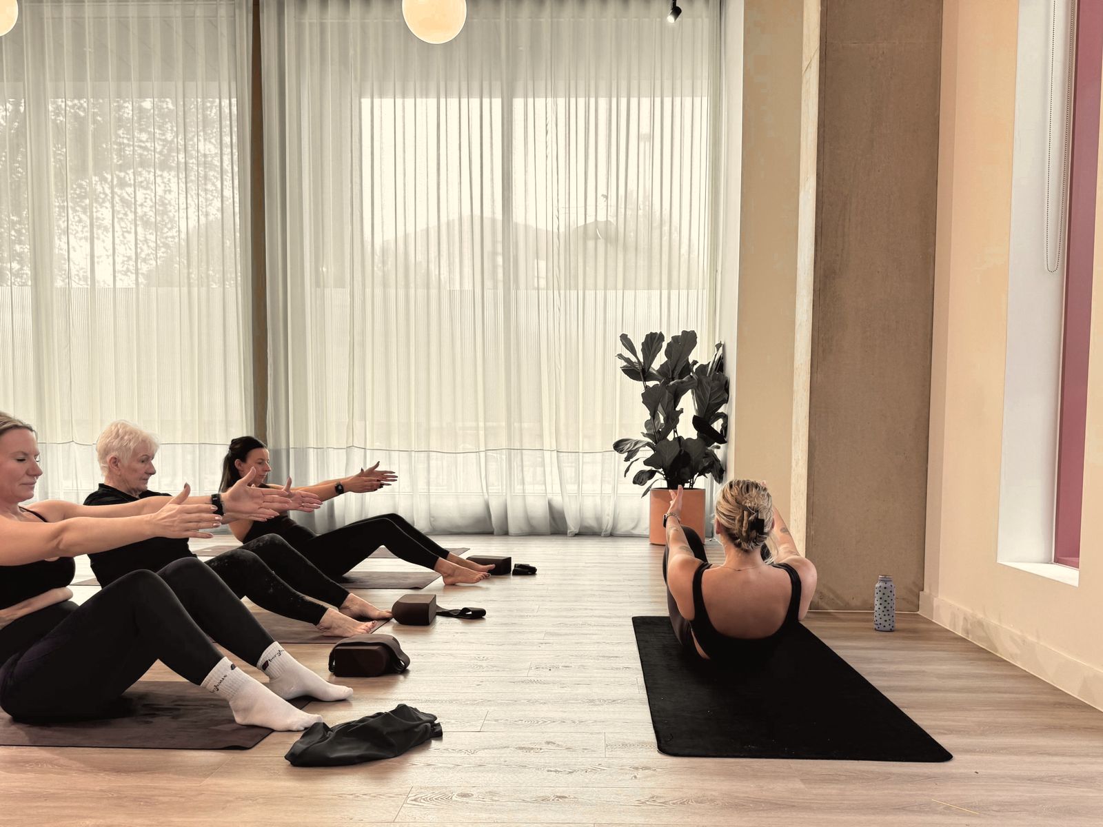 Aoife leading a group through a seated series from the front of the room