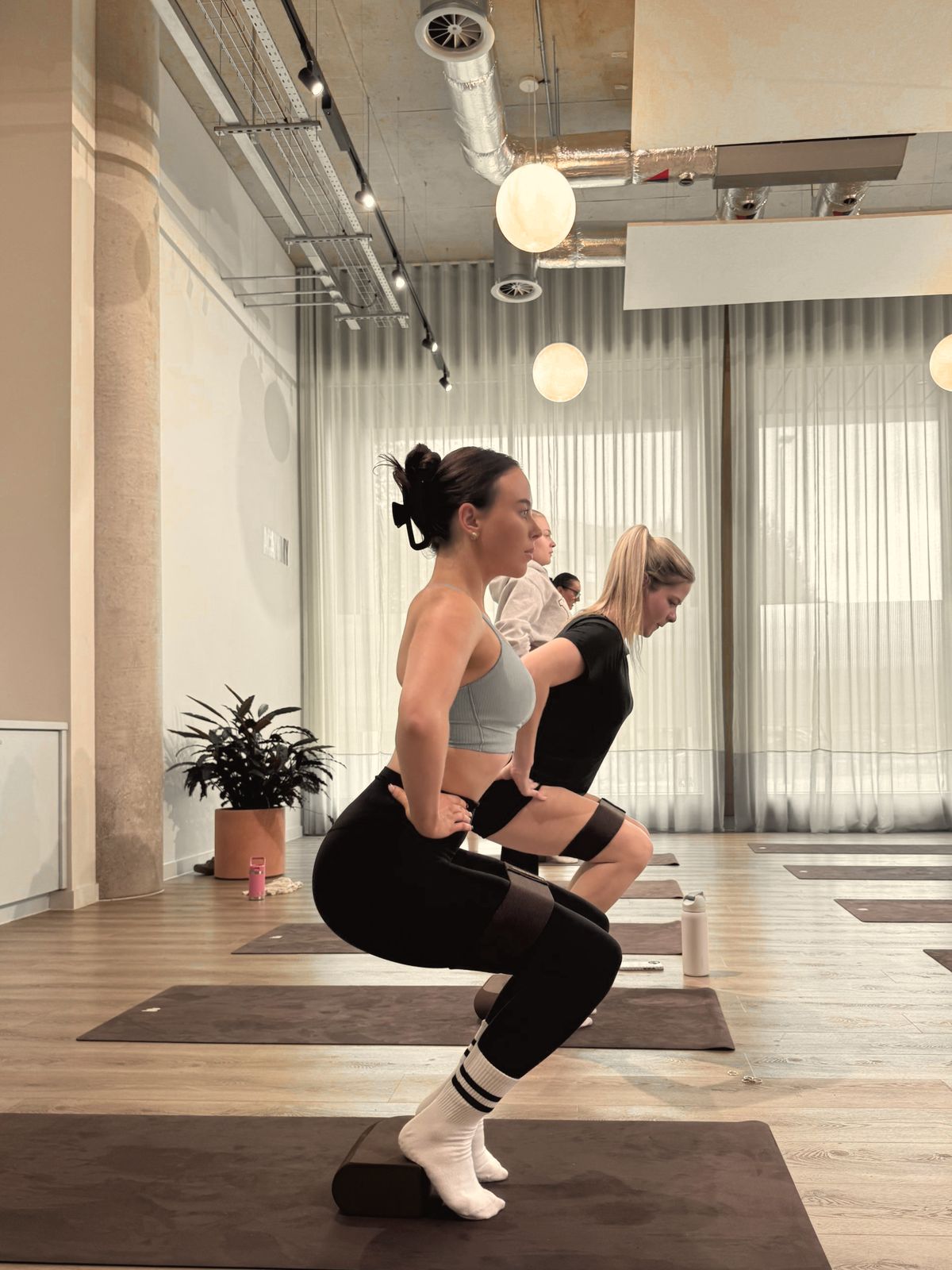 A row of participants holding a banded squat on blocks